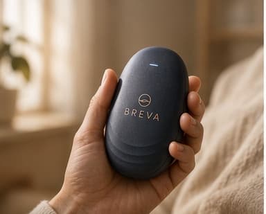 BREVA held gently in one hand, indicator light glowing